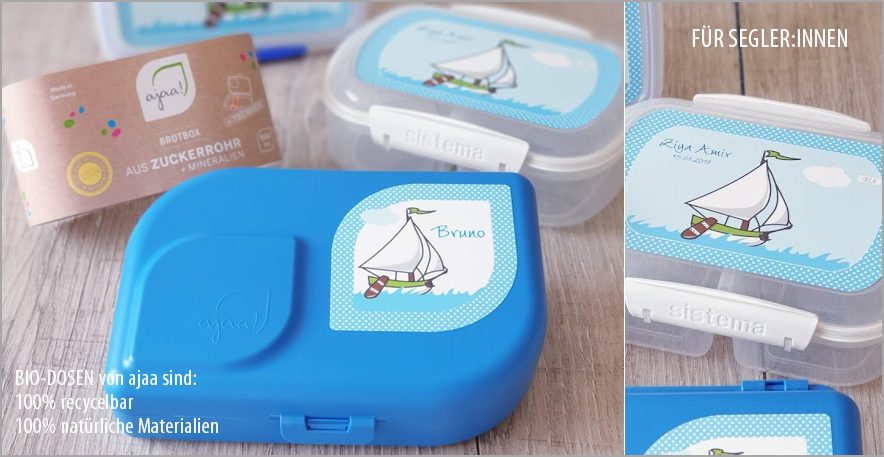 Verschiedene Brotdosen Bunte Brotdosen mit Segelboot-Motiv auf dem Deckel und einer transparenten Box.