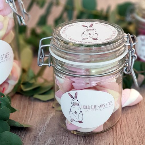 Eine Hand steckt etwas in eine hellblaue Spardose mit dem Namen "NICK".